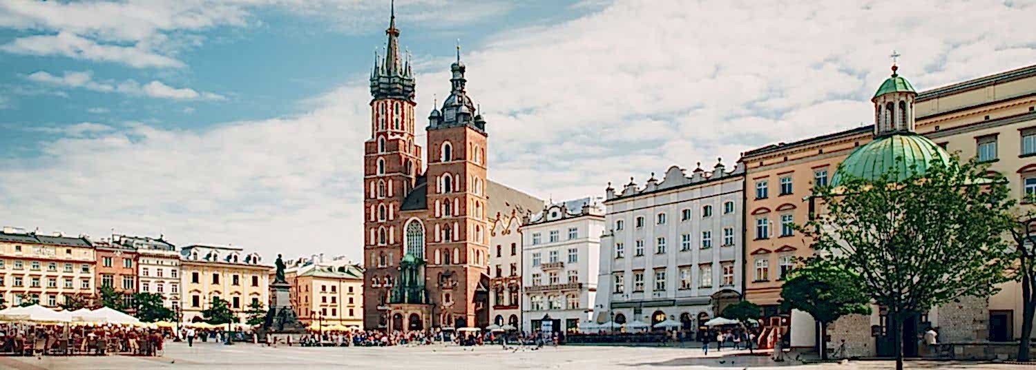 old town square with very few people on a partly cloudy day in krakow, poland