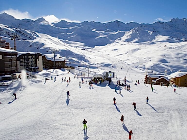 overhead view of skiers heading down a snowy mountain at a vegan friendly ski resort on a bright and sunny day