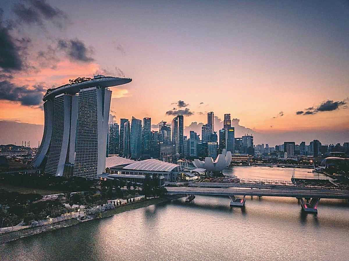 famous marina in singapore as the sun is setting with a pink and orange sky