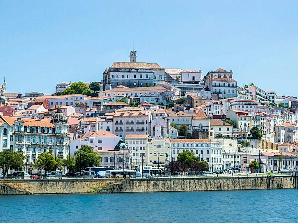 city view of coimbra from across the river on a partly cloudy day