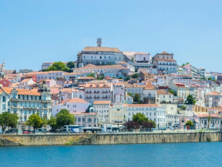 city view of coimbra from across the river on a partly cloudy day