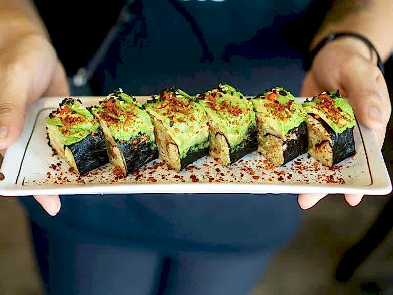 vegan sushi rolls topped with avocado and plant based caviar at a restaurant in singapore