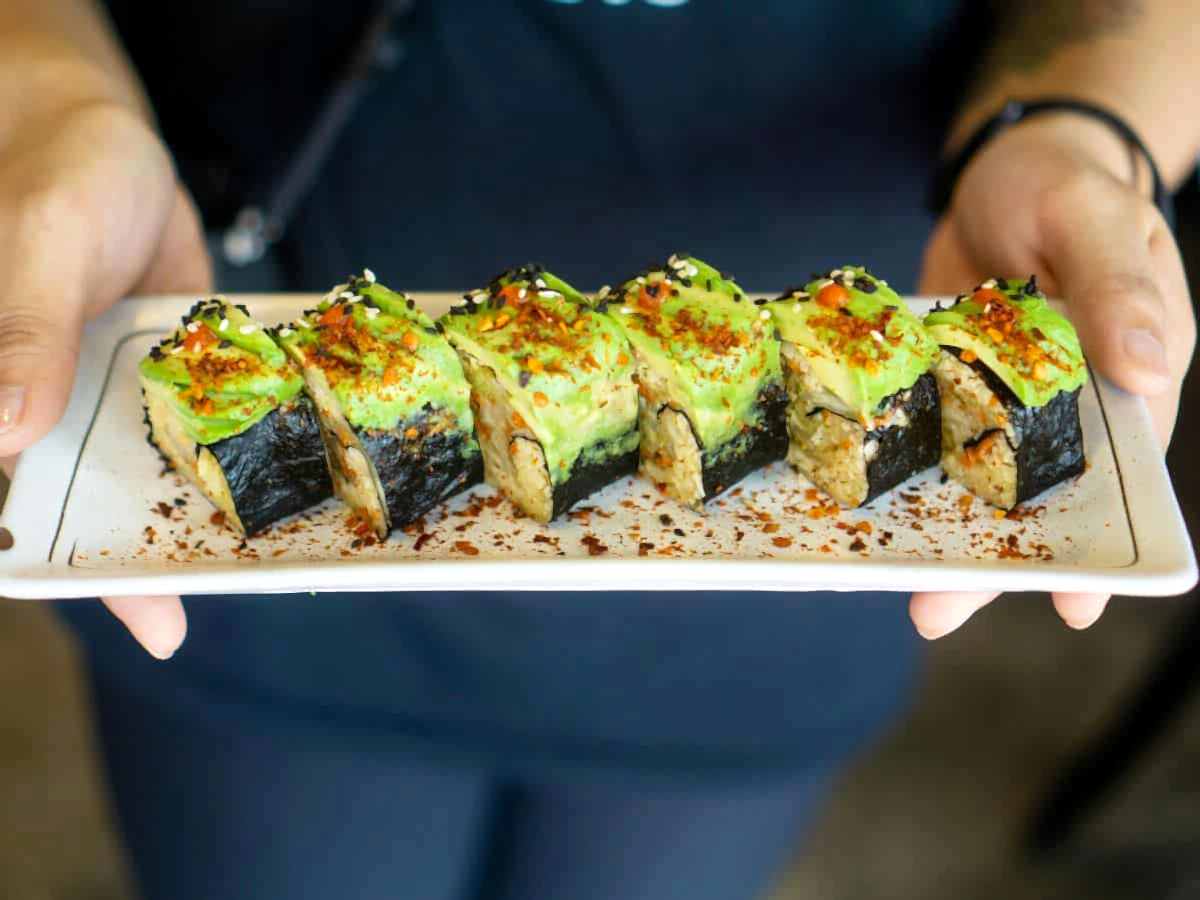 vegan sushi rolls topped with avocado and plant based caviar at a restaurant in singapore